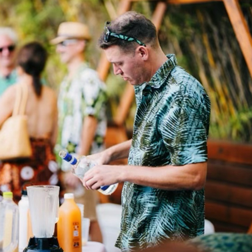 man in colorful shirt makes a drink